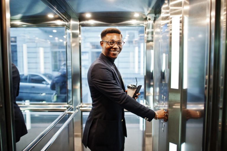 A young business man pushes the elevator button